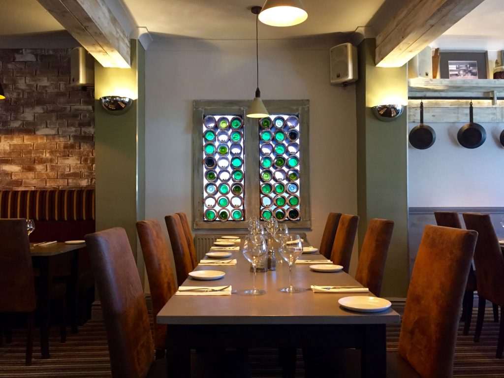 Pulcinella table setting beside the distinctive bottle wall